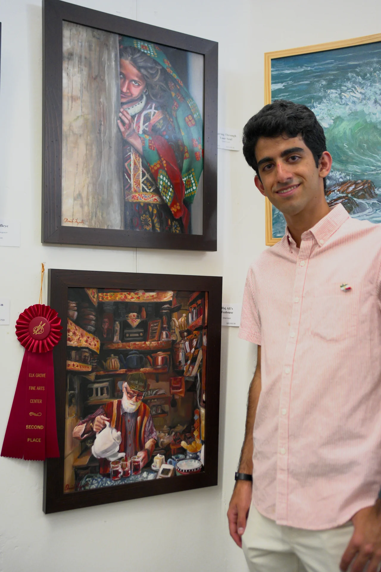 Omid Izadi beside his paintings and the second-place ribbon for Haj Ali’s Teahouse at Elk Grove Fine Arts Center